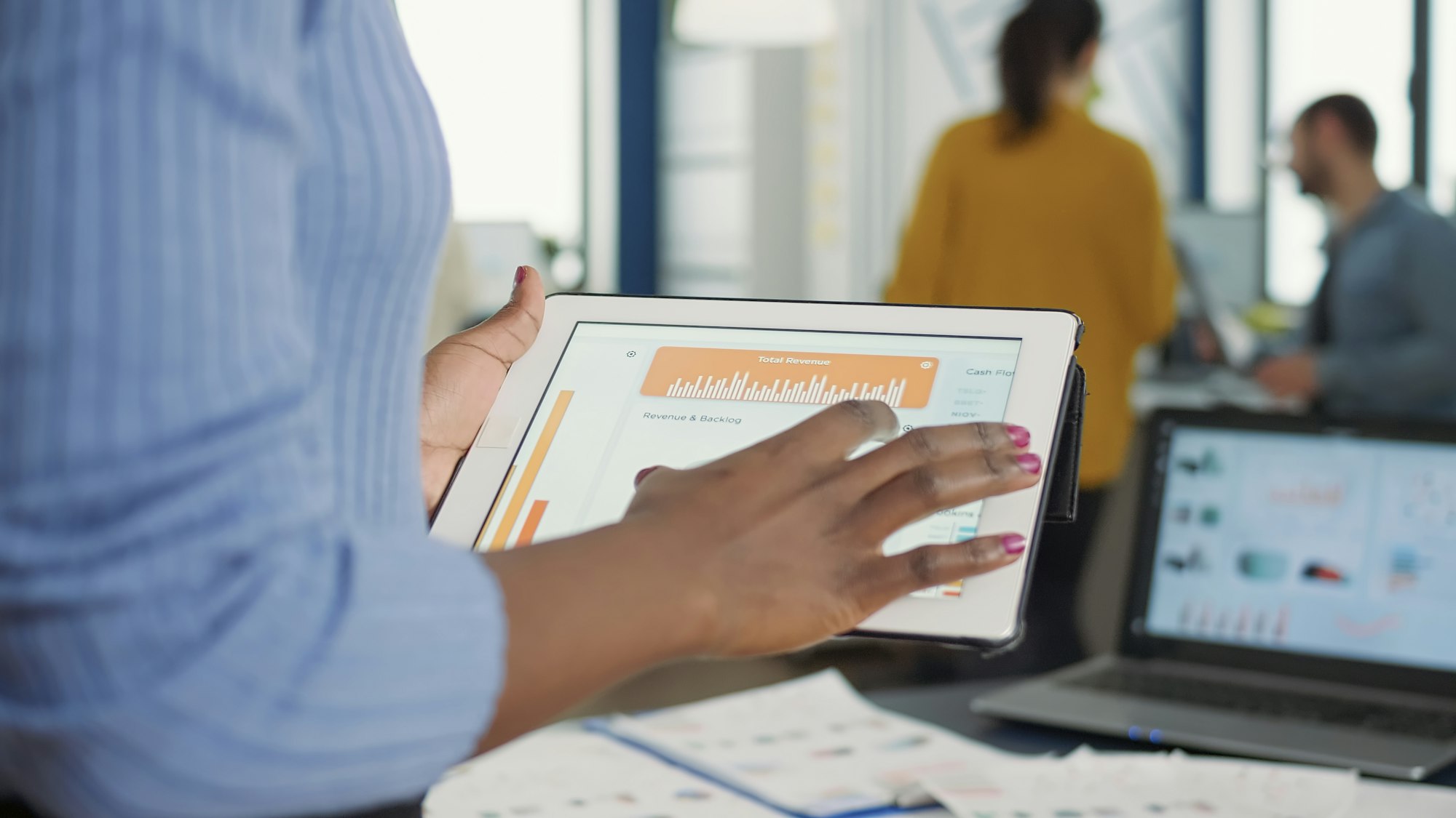 Closeup of african american woman hands picking up tablet interacting with touchscreen looking at